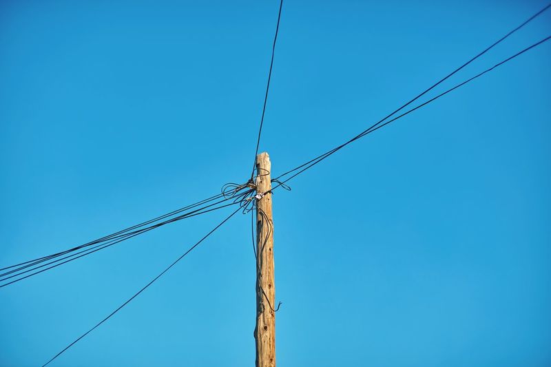 Low angle view of cables on bamboo against clear sky