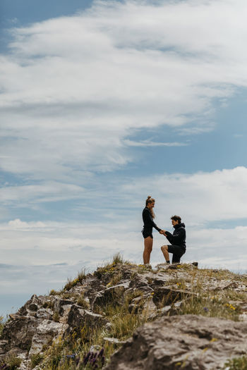 Happy boyfriend puts a ring on his girlfriend's hand after proposal