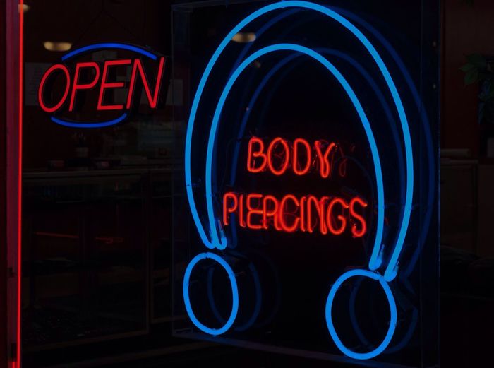 Close-up of neon signs over black background