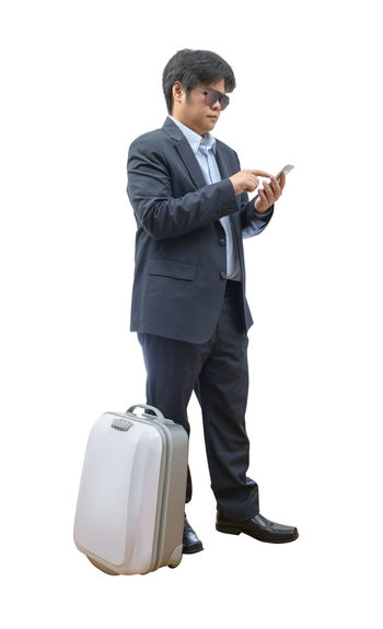 Young man using smart phone against white background