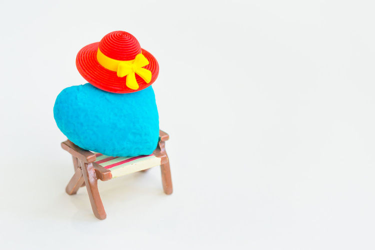 Close-up of multi colored hat on table against white background