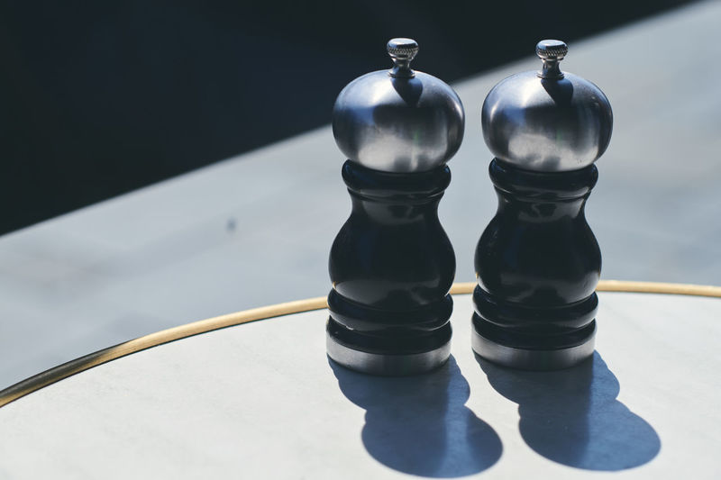 High angle view of salt and pepper shaker on table at sidewalk cafe