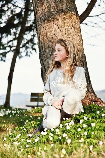 Portrait of girl sitting on tree