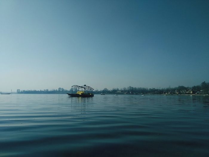Lone boat in sea against clear sky