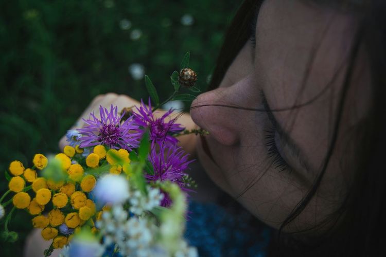 Close-up of woman smelling flowers