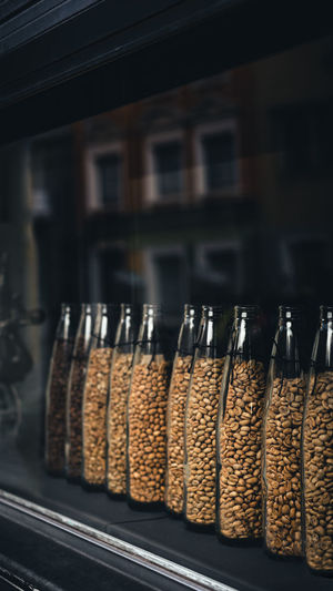 Glass jars of coffee beans stand behind a coffee shop