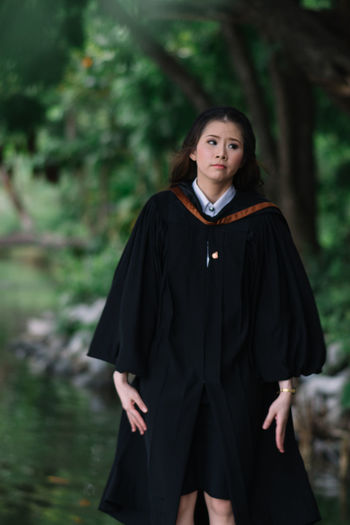 Portrait of smiling young woman standing in forest