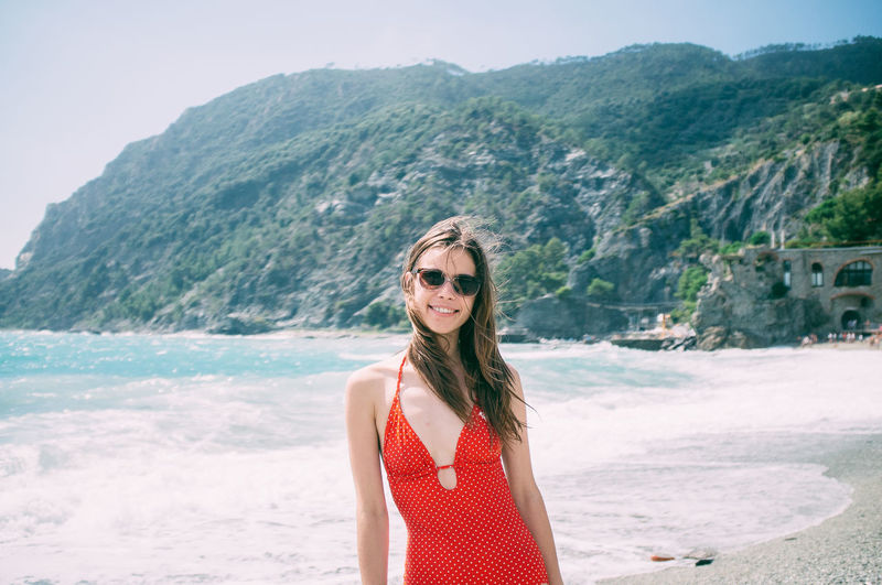 Portrait of young woman wearing red swimsuit on beach