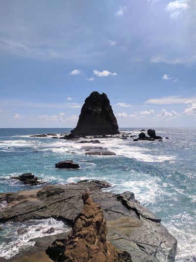 Scenic view of rocks in sea against sky