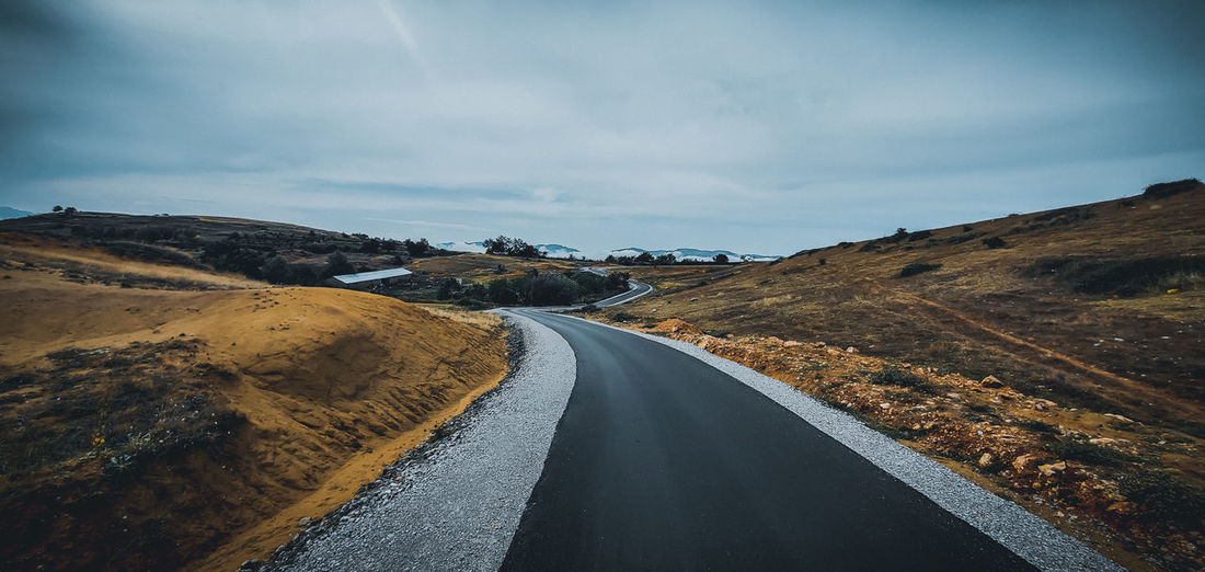 Empty road along countryside landscape