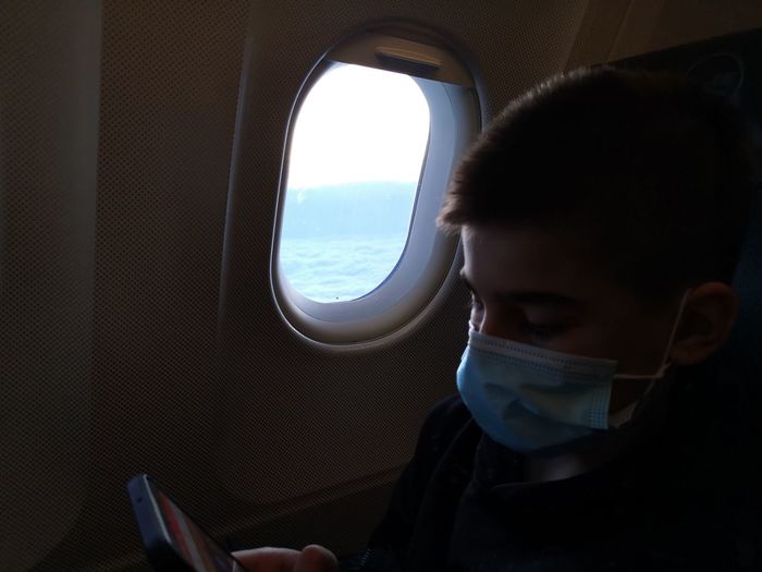 Portrait of man looking through airplane window