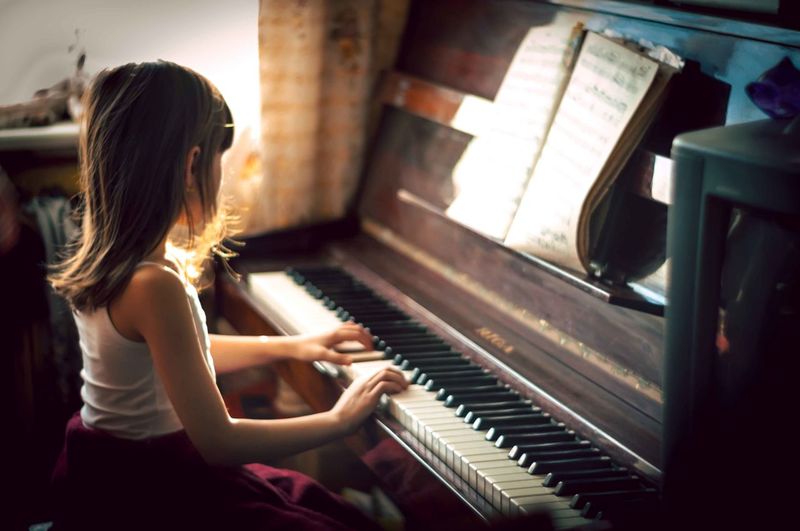 Listen she is playing the piano. Playing the Piano. Play the Piano. Girl playing the Piano. Play on the Piano.