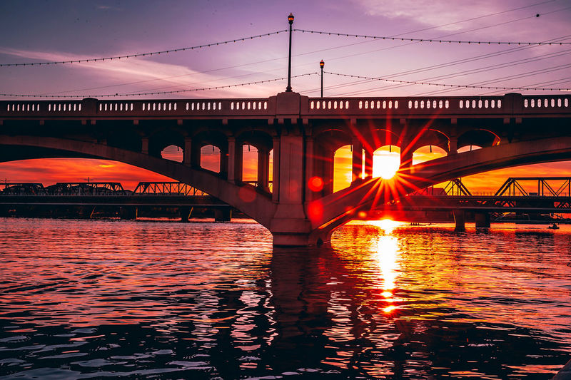 Bridge over river during sunset