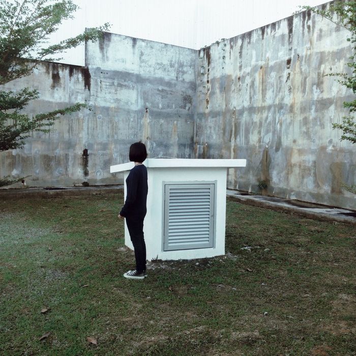 Full length side view of woman standing on field by vent
