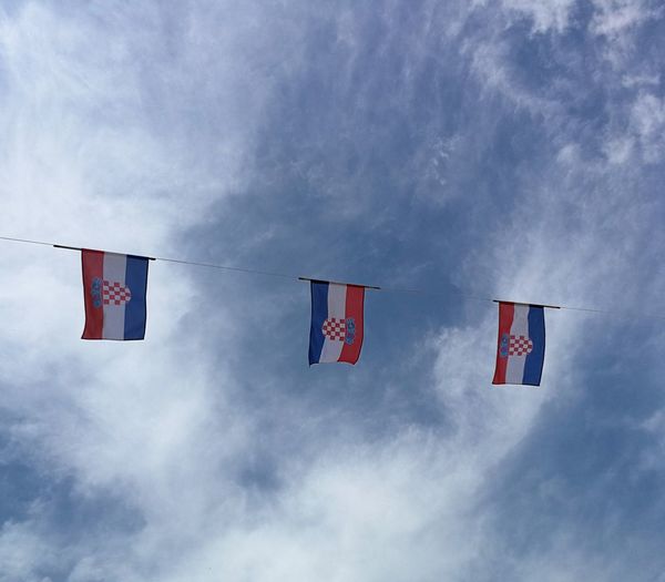 Low angle view of croatian flags waving on rope against sky