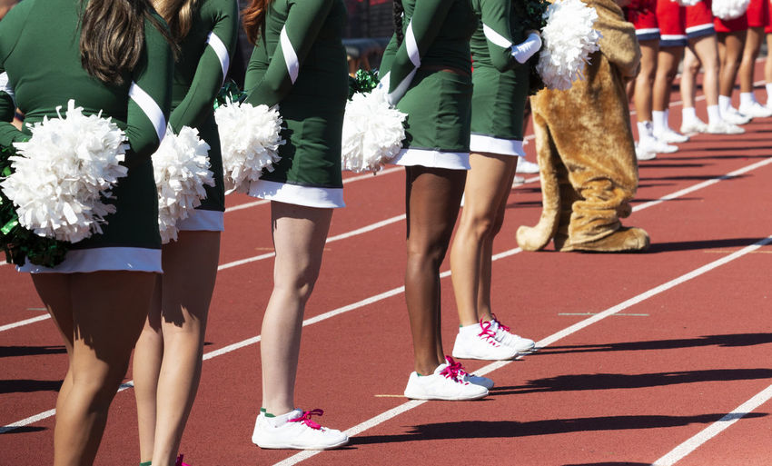 Side view of high school cheerleaders during a football game