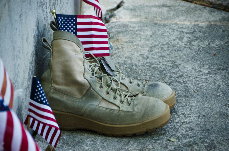 Close-up of shoes with american flags on footpath