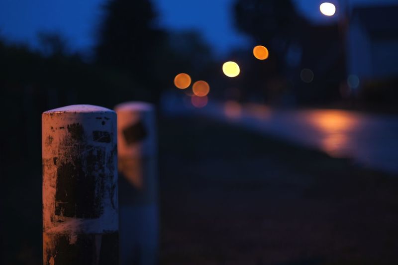 Close-up of illuminated light bulb against blue sky at night