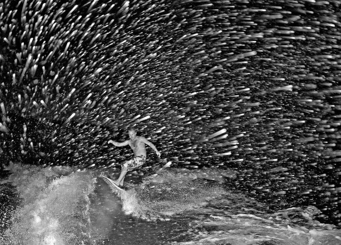 Man surfing in sea at night