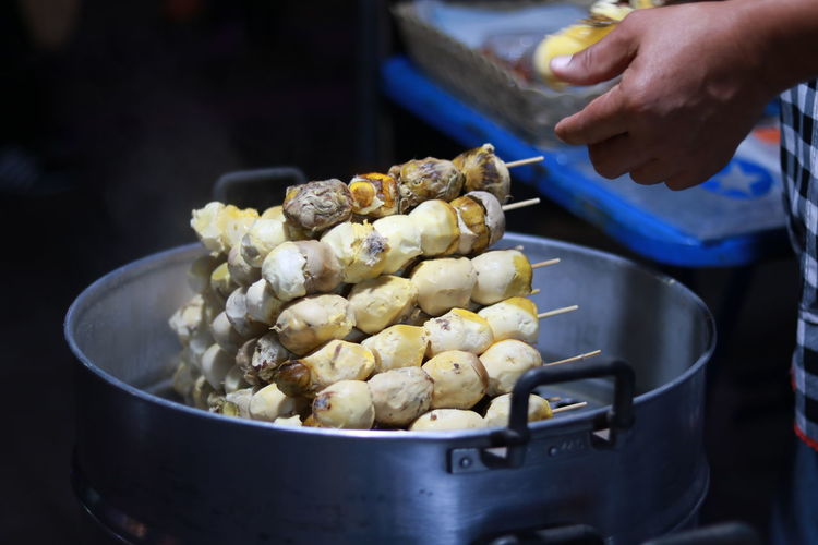 Cropped image of person preparing food at market stall