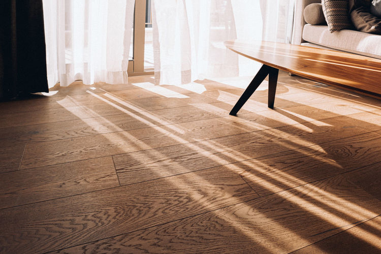 Modern room interior with an open window in minimal style. transparent tulle with morning sun rays 