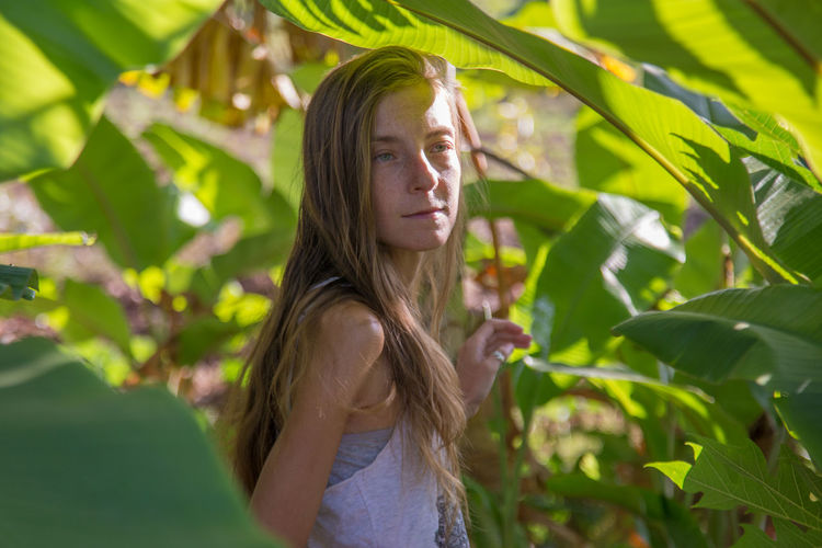 Young woman standing in greenhouse
