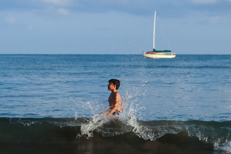 Man surfing on sea against sky