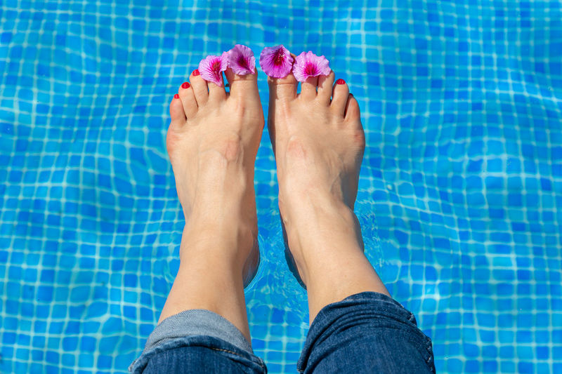 Low section of woman feet in swimming pool