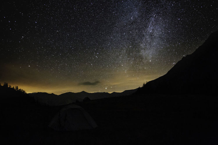 Scenic view of silhouette mountain against star field at night