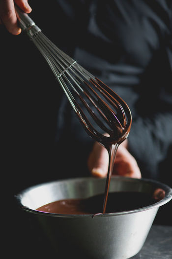 Close-up of wire whisk and melted chocolate