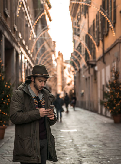 Young man using mobile phone in city