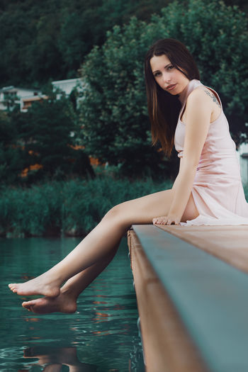 Portrait of woman sitting at poolside