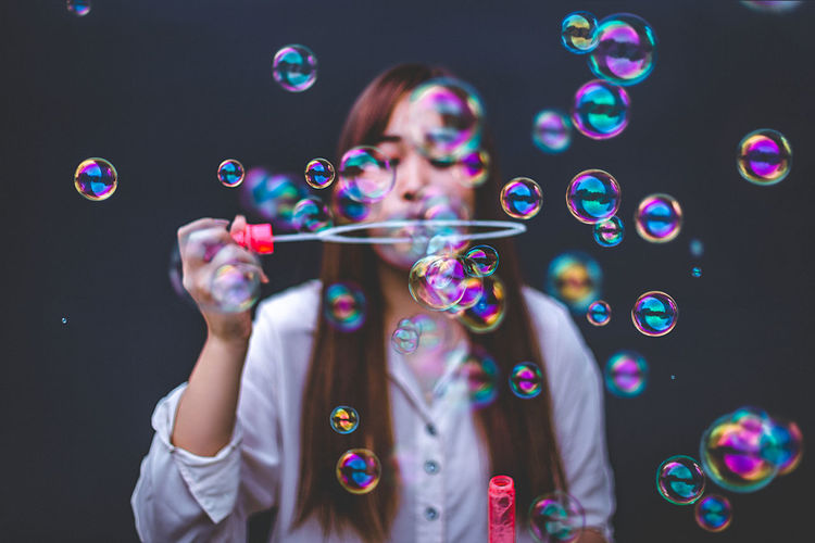 Woman blowing bubbles in city