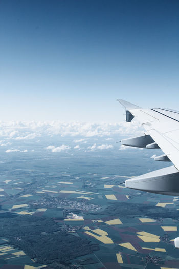Airplane flying over landscape against sky