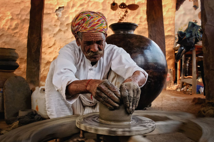 Man making earthenware at shop