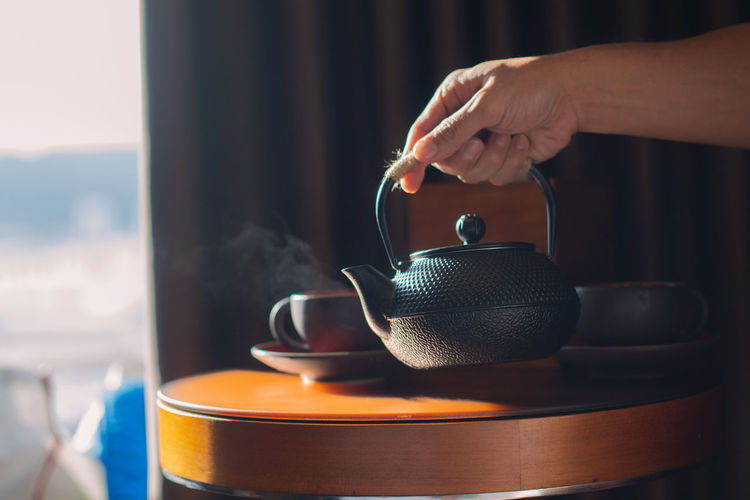 Close-up of hand holding tea kettle