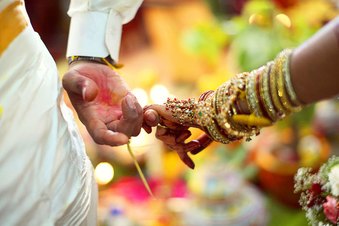 Cropped hand of couple holding hands during wedding