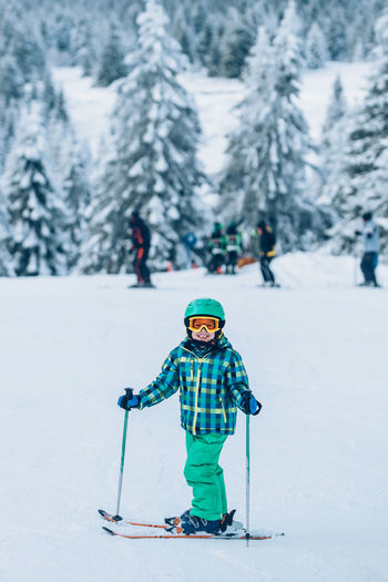 Portrait of boy skiing on snow covered land