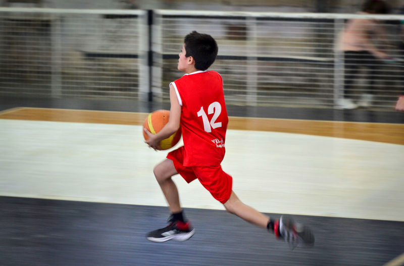 Boy basketball player runs in a game to score