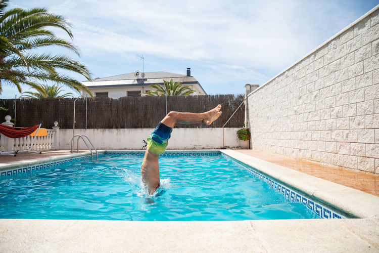 Full length of man jumping in swimming pool