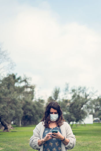 Woman wearing sunglasses on field against sky