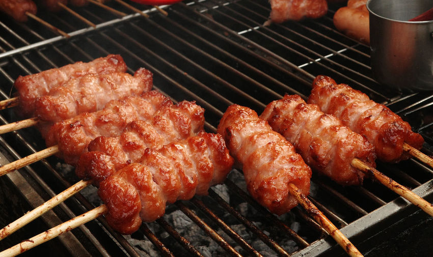 Grilled pork sausage on charcoal. nem nuong ninh hoa on street of hi chi minh city, viet nam. 
