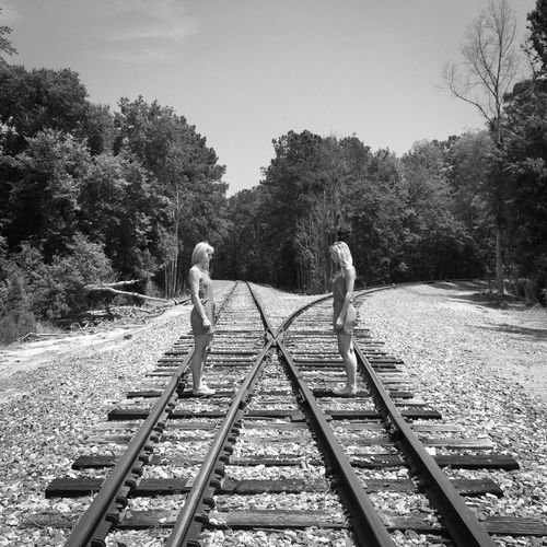 Two women standing on railroad track