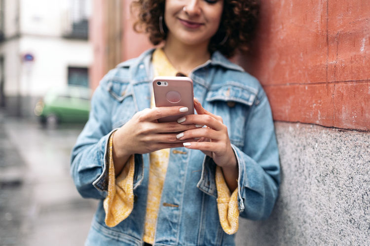 Young man using mobile phone in city