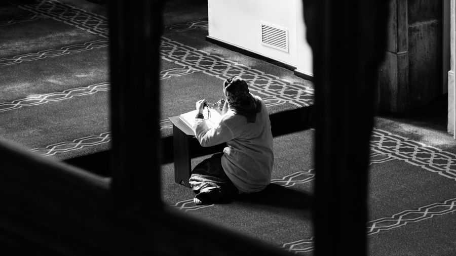 Rear view of woman praying in arap mosque