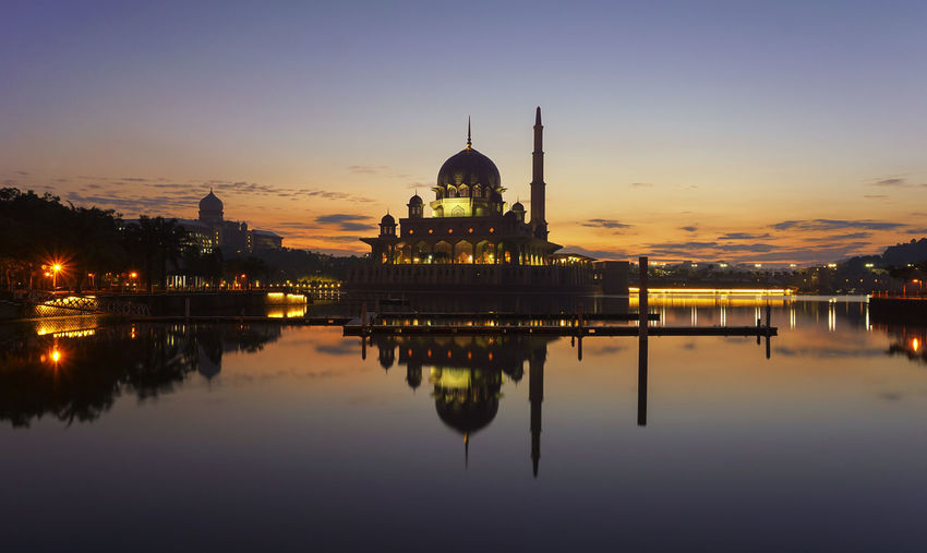 Reflection of illuminated putra mosque on putrajaya lake during sunset