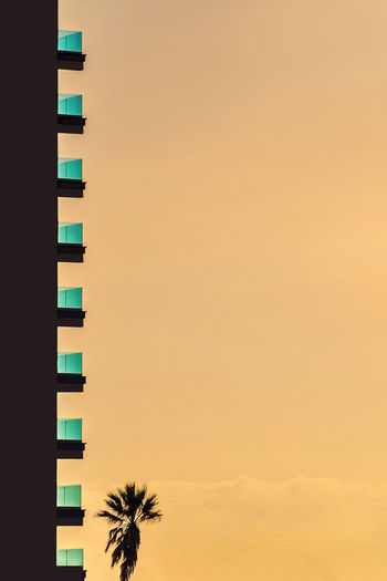 Side view of balconies on high rise building against sunset