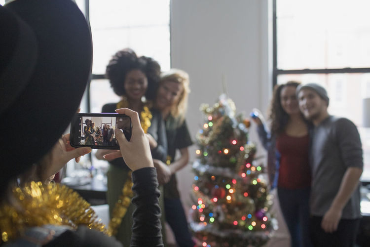 A group of people taking a photo with a christmas tree