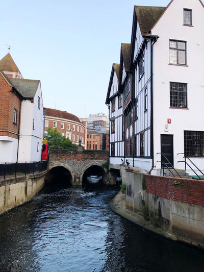 Bridge over canal amidst buildings against sky