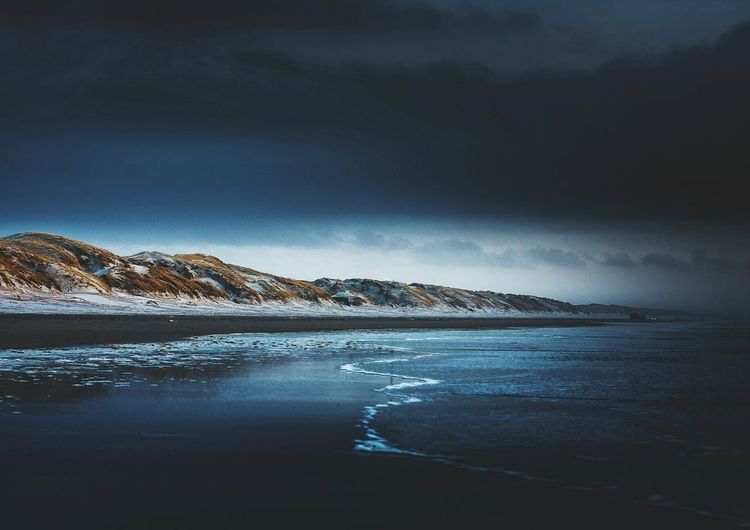 Scenic view of beach against sky at night